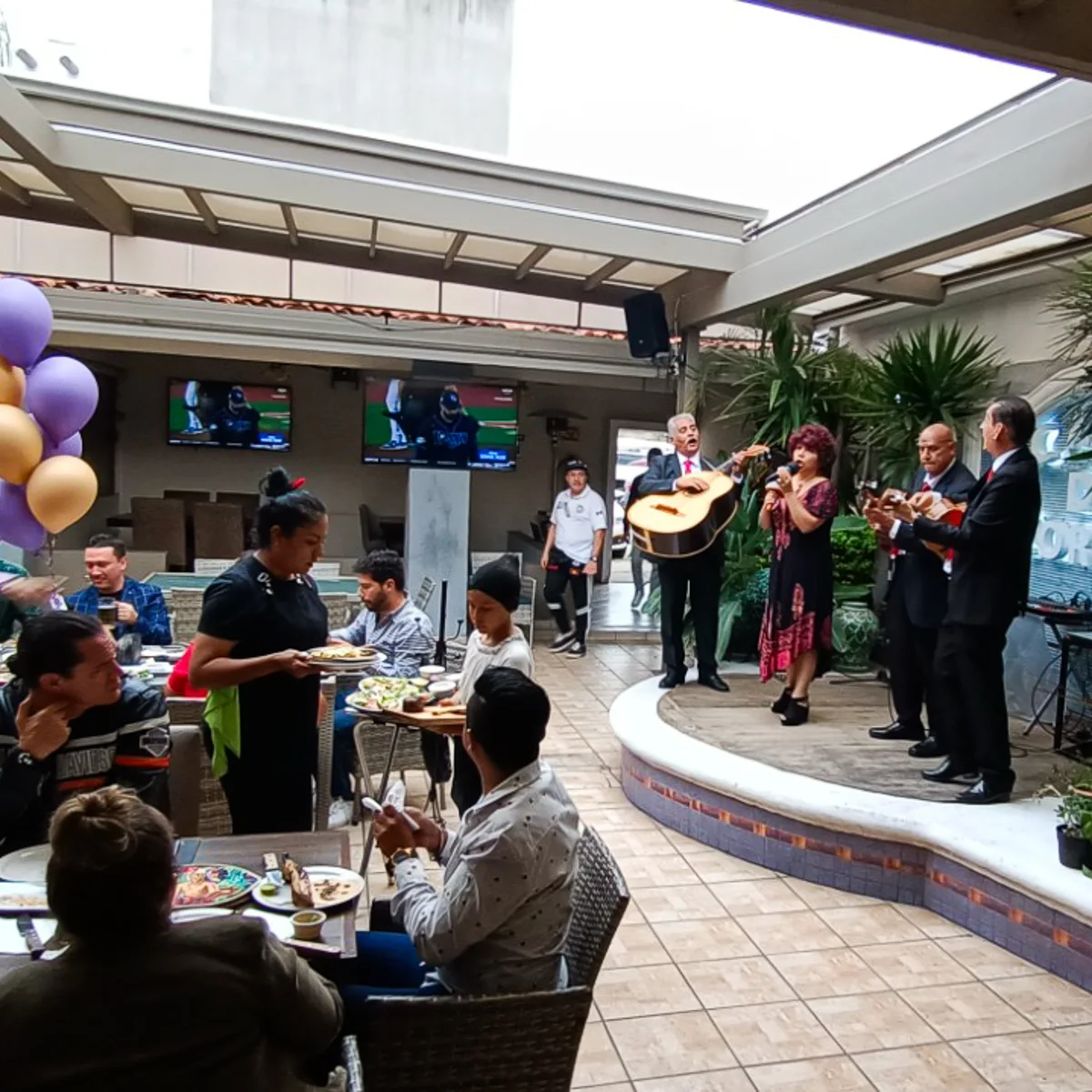 Músicos y cantantes presentándose en vivo en el escenario de la terraza