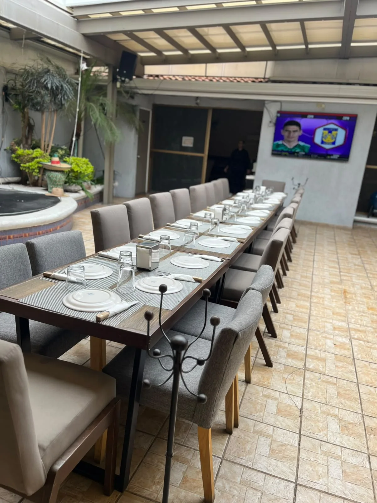 Vista amplia de mesa larga, escenario y circulación de la terraza en Sonora's Carbón y Sal