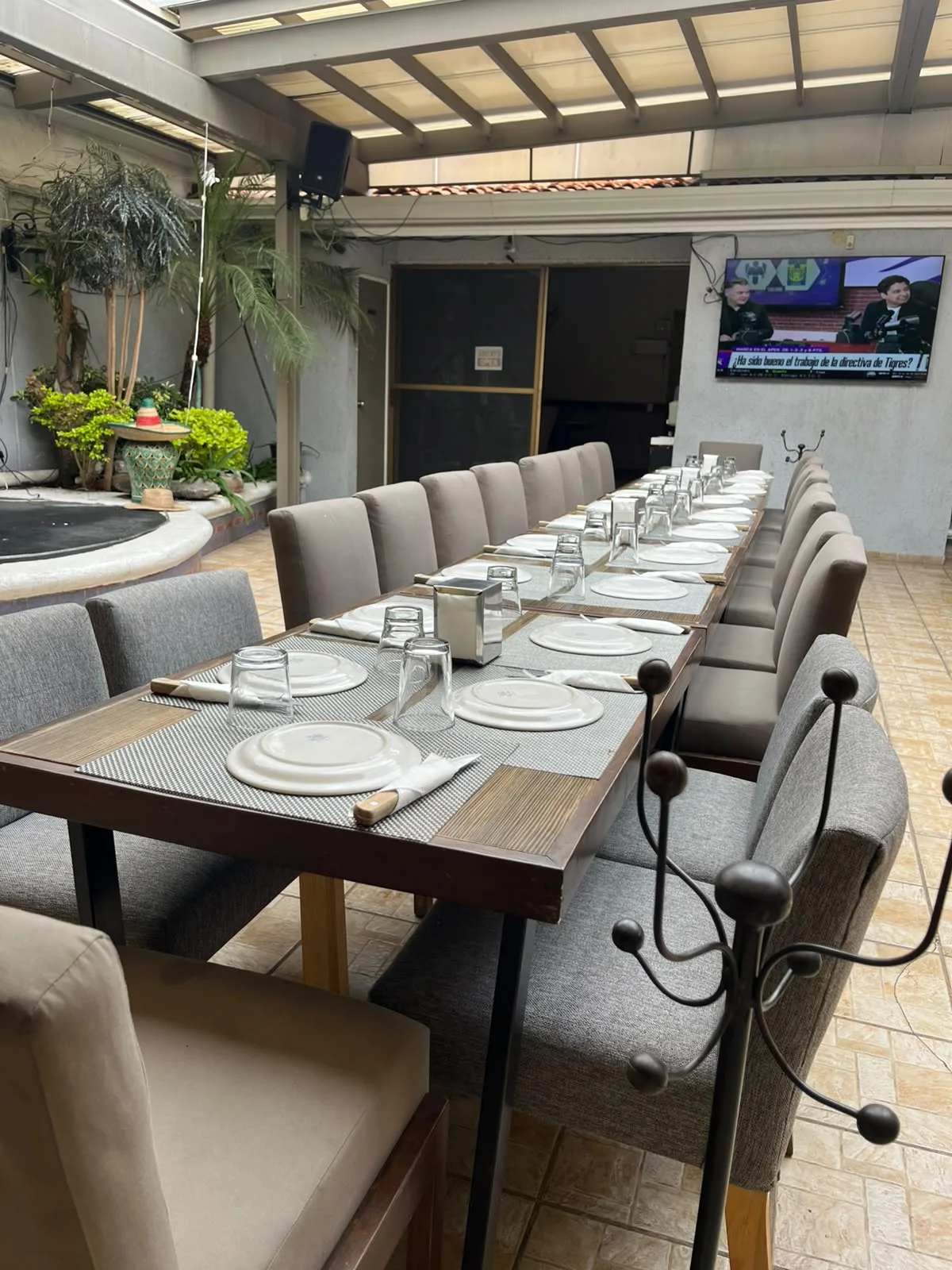 Mesa larga montada con mantelería y vajilla para cena de grupo empresarial en Sonora's Carbón y Sal