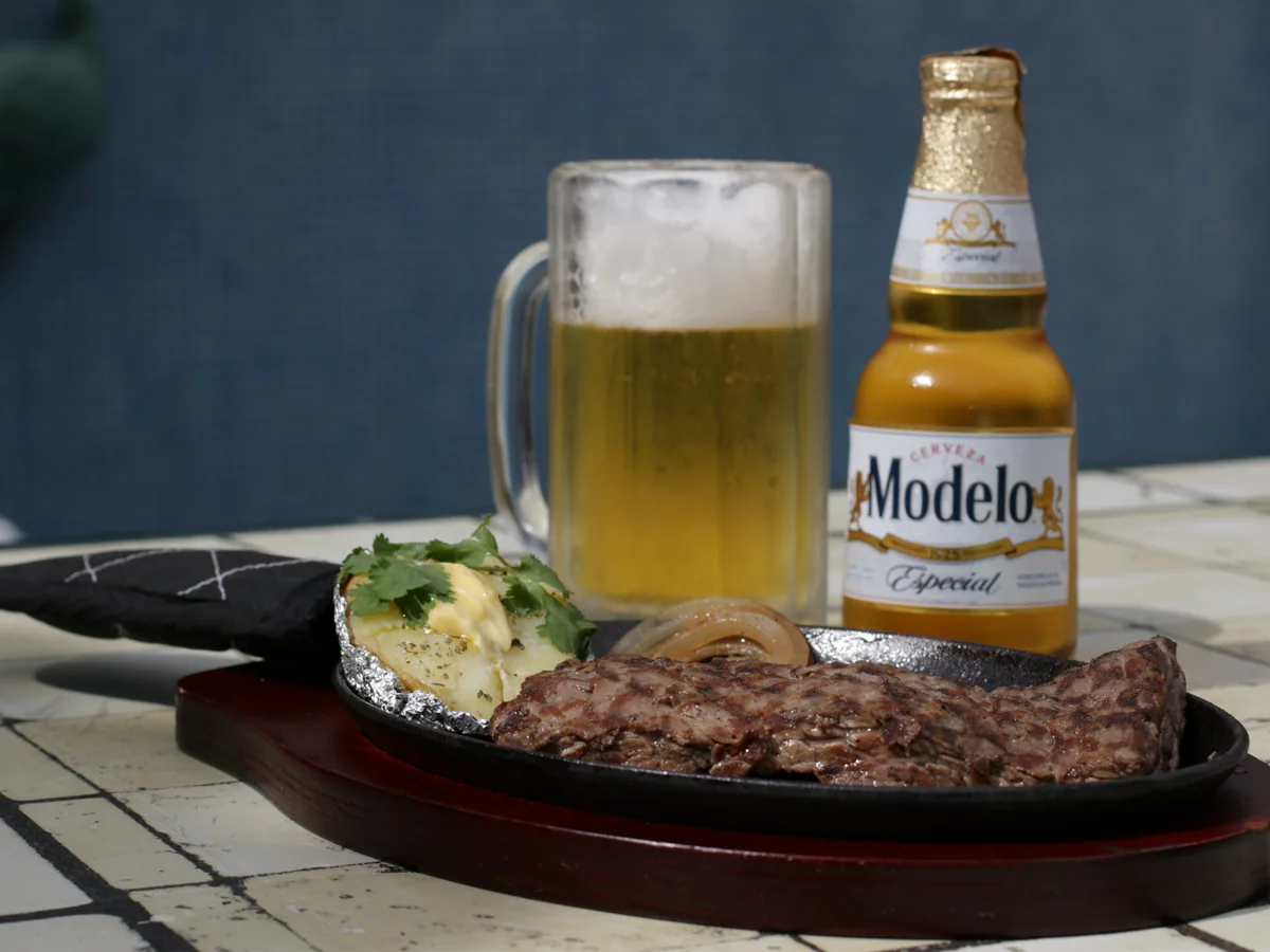Cabrería al carbón con papa y cerveza en Sonora's Carbón y Sal